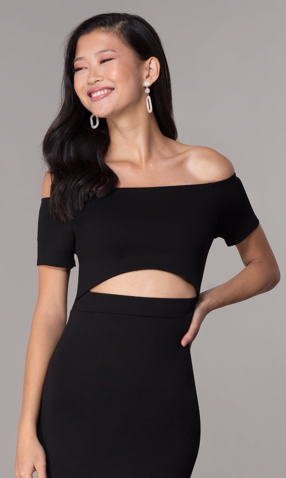 A woman in the Off-the-Shoulder Short Cut-Out Party Dress 3076 smiles with her hand on her hip, posing against a plain background.